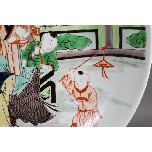 334 - A Chinese famille verte shallow bowl or charger painted in polychrome enamels with two female musici... 