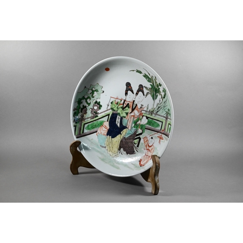 334 - A Chinese famille verte shallow bowl or charger painted in polychrome enamels with two female musici... 