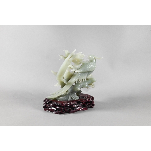 343 - A Chinese celadon 'new jade' bowenite ornament carved as two exotic birds perching amongst foliage a... 