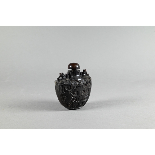 357 - A Chinese hardwood snuff bottle and stopper, stippled and carved in relief with taotie mask decorati... 