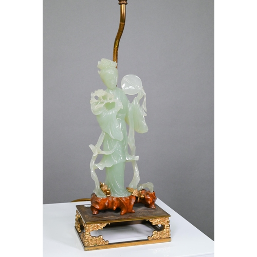 369 - A Chinese bowenite gilt metal and hardwood lamp, the pale green stone figure carved as a courtesan h... 