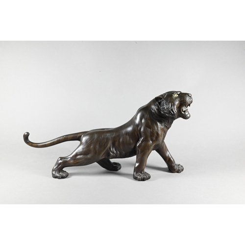 384A - A Japanese Meiji period (1868-1912) bronze prowling tiger signed by Seiya, 35 cm wide to/w a similar... 