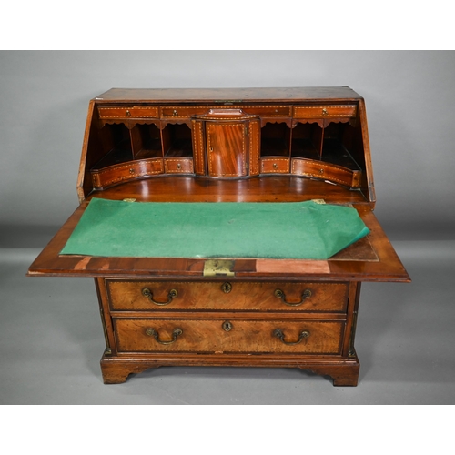 827 - A George III feather-banded mahogany bureau, the fall enclosing a well fitted interior over four lon... 