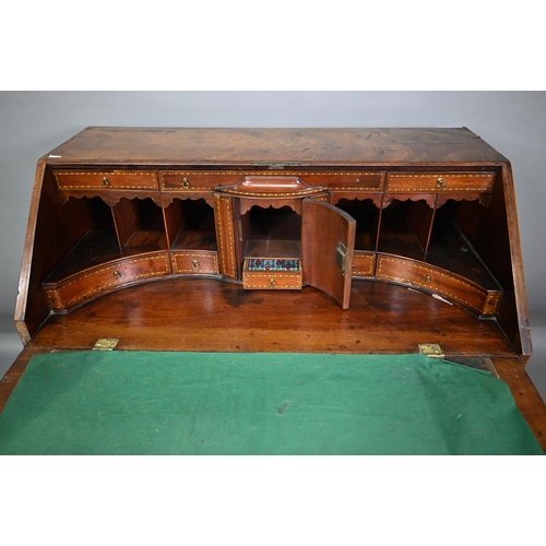 827 - A George III feather-banded mahogany bureau, the fall enclosing a well fitted interior over four lon... 