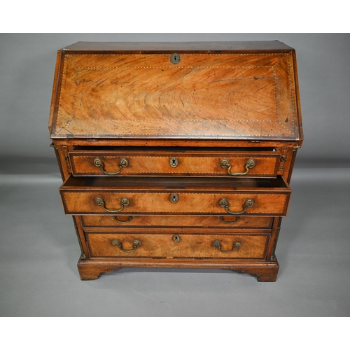 827 - A George III feather-banded mahogany bureau, the fall enclosing a well fitted interior over four lon... 