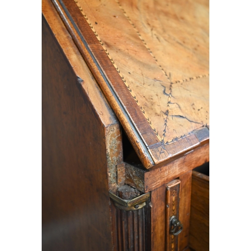 827 - A George III feather-banded mahogany bureau, the fall enclosing a well fitted interior over four lon... 