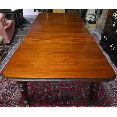 834 - A Victorian mahogany draw leaf extending dining table, raised on turned part gadrooned legs to brass... 