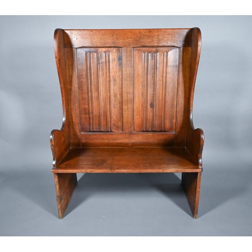 837 - A traditional oak high back settle with moulded back panels over shaped arms, 95 cm x 50 cm x 126 cm... 