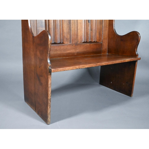 837 - A traditional oak high back settle with moulded back panels over shaped arms, 95 cm x 50 cm x 126 cm... 