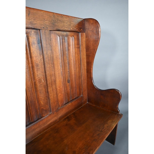 837 - A traditional oak high back settle with moulded back panels over shaped arms, 95 cm x 50 cm x 126 cm... 