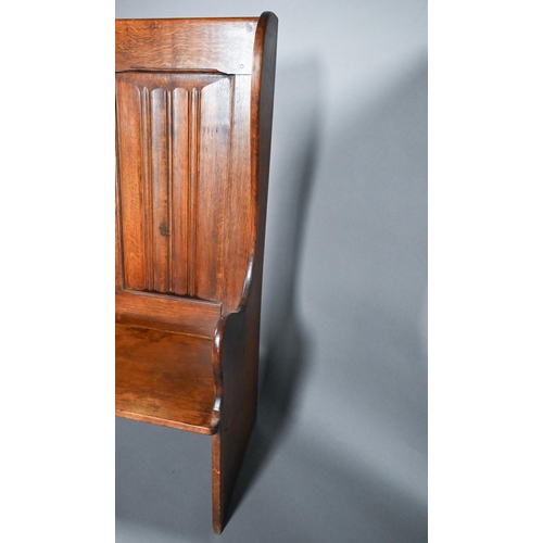 837 - A traditional oak high back settle with moulded back panels over shaped arms, 95 cm x 50 cm x 126 cm... 