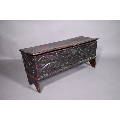 838 - A 17th century oak/elm six plank coffer, the hinged top with carved edge over bold leaf carved front... 