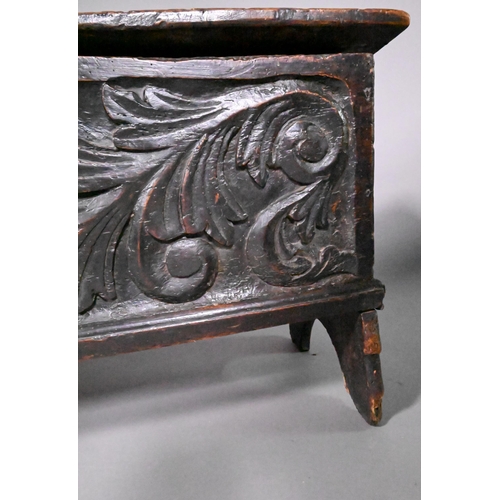 838 - A 17th century oak/elm six plank coffer, the hinged top with carved edge over bold leaf carved front... 