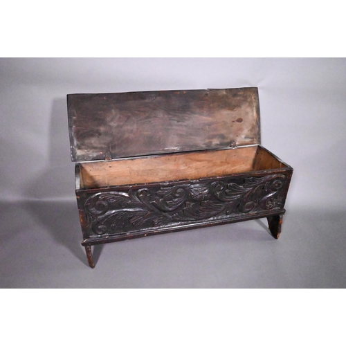 838 - A 17th century oak/elm six plank coffer, the hinged top with carved edge over bold leaf carved front... 