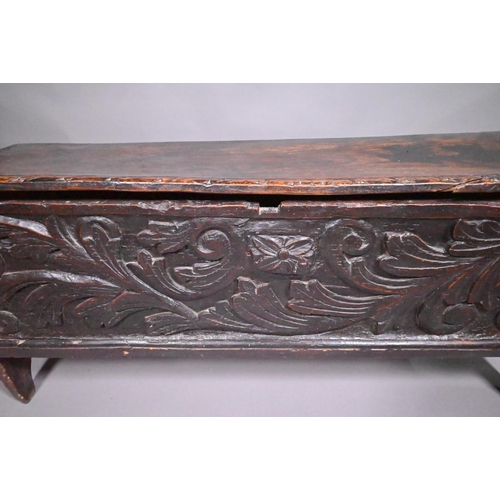 838 - A 17th century oak/elm six plank coffer, the hinged top with carved edge over bold leaf carved front... 
