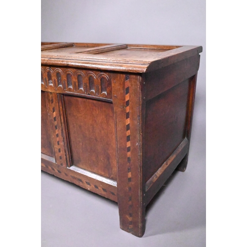 842 - A 17th/18th century chequer inlaid oak coffer, with arcaded frieze over a triple panel front on stil... 