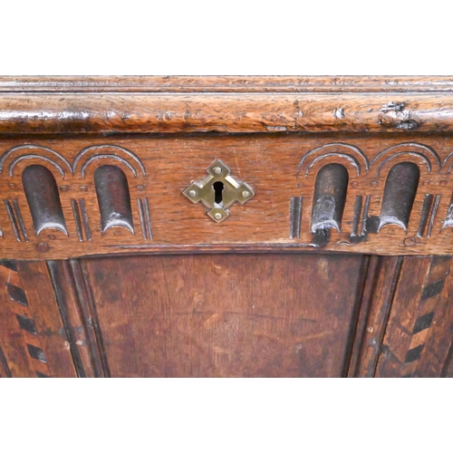 842 - A 17th/18th century chequer inlaid oak coffer, with arcaded frieze over a triple panel front on stil... 