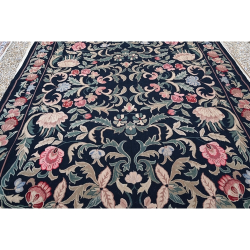 909 - A Belgian floral design needlepoint rug, black ground, 325 cm x 255 cm