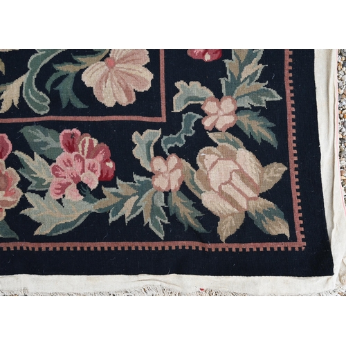 909 - A Belgian floral design needlepoint rug, black ground, 325 cm x 255 cm