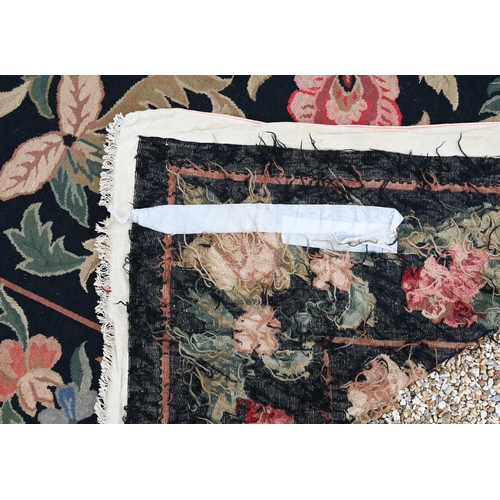 909 - A Belgian floral design needlepoint rug, black ground, 325 cm x 255 cm