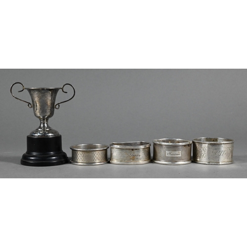 93 - Nine various silver napkin rings to/w a Port decanter label, miniature trophy cup and a cased set of... 