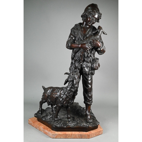 953 - A large dark brown-patinated bronze group, boy goatherd carrying a newborn kid, the mother goat foll... 