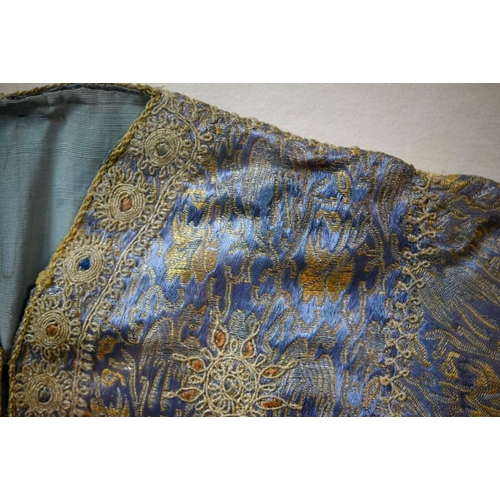 973 - A vintage Northern Indian embroidered jacket with gold and silver thread on a blue ground, in glazed... 