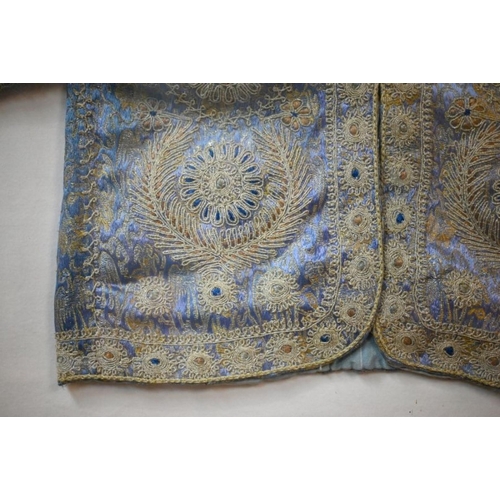 973 - A vintage Northern Indian embroidered jacket with gold and silver thread on a blue ground, in glazed... 