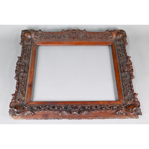 993 - An antique Anglo-Indian padouk wood picture frame, finely carved in the Rococo manner with floral an... 