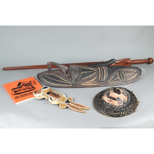 998 - A Papua New Guinea tribal carved wood shield, worked with a mask with prominent nose below a bird, 7... 