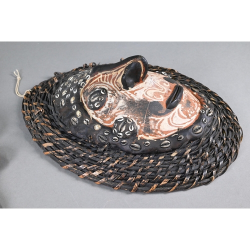 998 - A Papua New Guinea tribal carved wood shield, worked with a mask with prominent nose below a bird, 7... 
