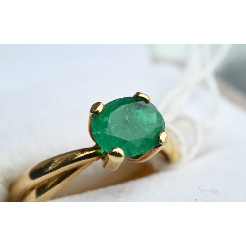 227 - An oval included green emerald ring in high prong setting, and conjoined shank, yellow metal stamped... 