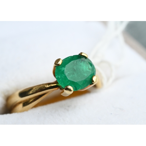 227 - An oval included green emerald ring in high prong setting, and conjoined shank, yellow metal stamped... 