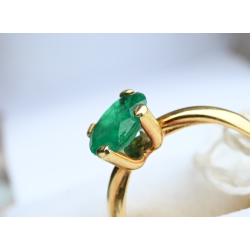 227 - An oval included green emerald ring in high prong setting, and conjoined shank, yellow metal stamped... 