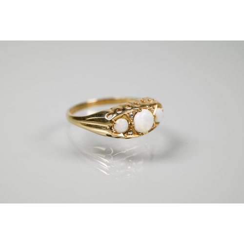233 - A 9ct gypsy-style ring set with three graduated circular opals with two small diamonds between, size... 