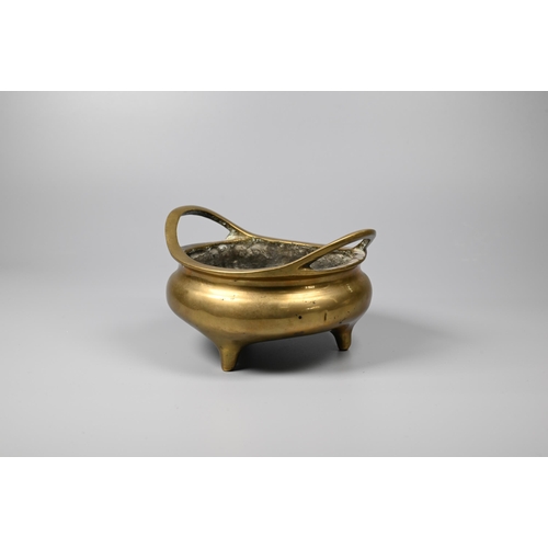 292 - A 19th century Chinese polished bronze censer with a pair of loop handles on a compressed globular b... 