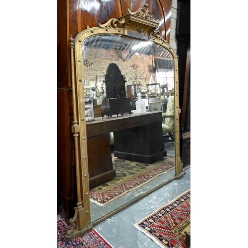 797 - A large Victorian giltwood and gesso overmantel mirror, the arched top centred by a polychrome depic... 