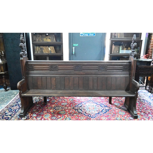 810 - A Victorian oak church pew with ornate carved ends, bible shelf to the reverse, circa 1870, 212 cm x... 