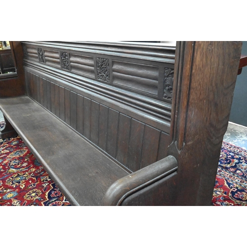 810 - A Victorian oak church pew with ornate carved ends, bible shelf to the reverse, circa 1870, 212 cm x... 