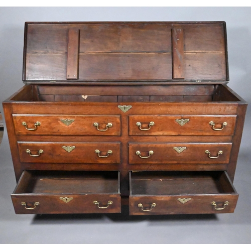 817 - An 18th century oak mule chest, the hinged top over four dummy drawer fronts and two drawers, with b... 