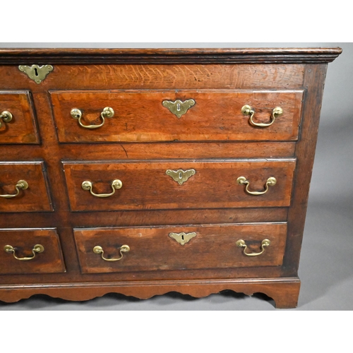 817 - An 18th century oak mule chest, the hinged top over four dummy drawer fronts and two drawers, with b... 