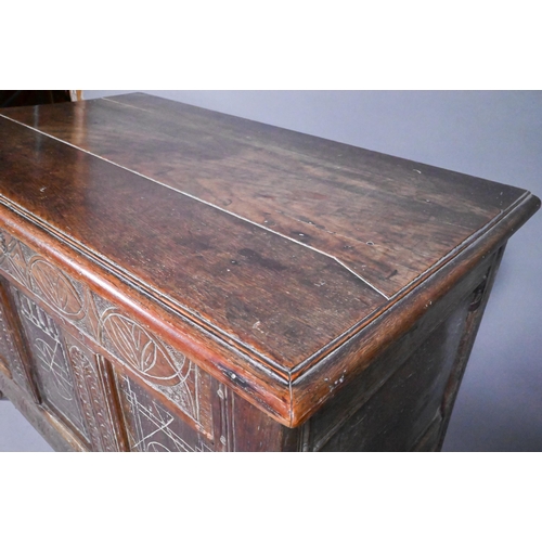 825 - An early 18th and later oak coffer, with lunette carved frieze over a trio of incised panels, on sti... 