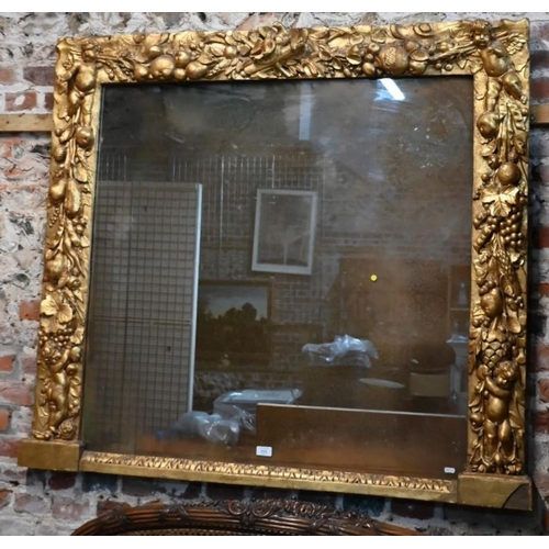 840 - A 18th century bacchanalian style giltwood and gesso frame fitted with a faux mirror comprised of wa... 