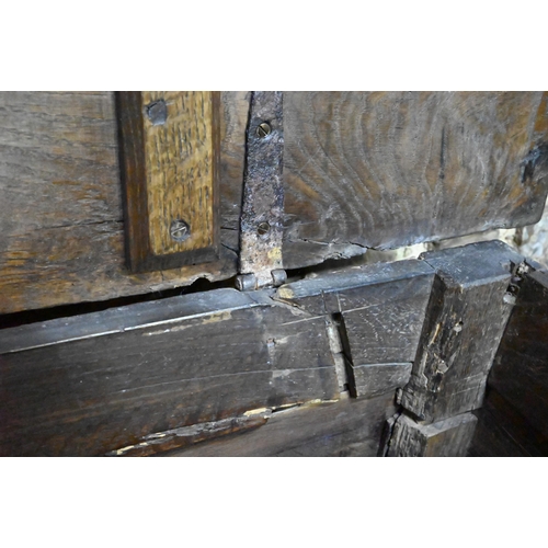 841 - A large Georgian oak coffer, the wide two plank top over a triple fielded panel front, raised on bun... 