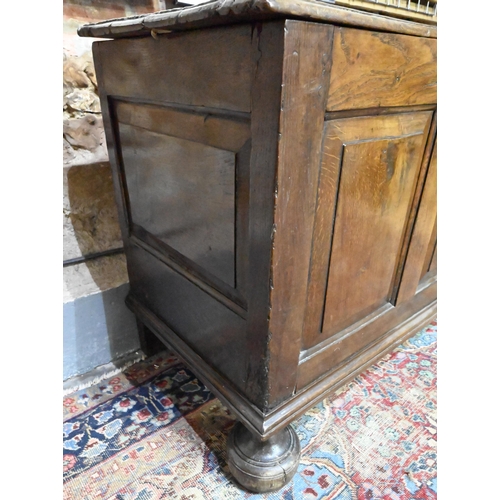 841 - A large Georgian oak coffer, the wide two plank top over a triple fielded panel front, raised on bun... 