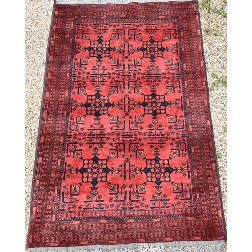 901 - A vintage Afghan rug, the red/brown ground with stylised geometric panels, 194 cm x 124 cm