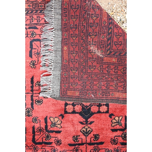 901 - A vintage Afghan rug, the red/brown ground with stylised geometric panels, 194 cm x 124 cm