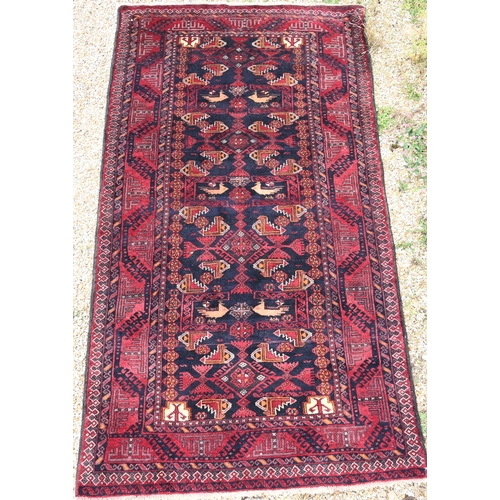 902 - A contemporary Persian Meshed Belouch rug, the blue/brown ground with stylised bird and floral desig... 