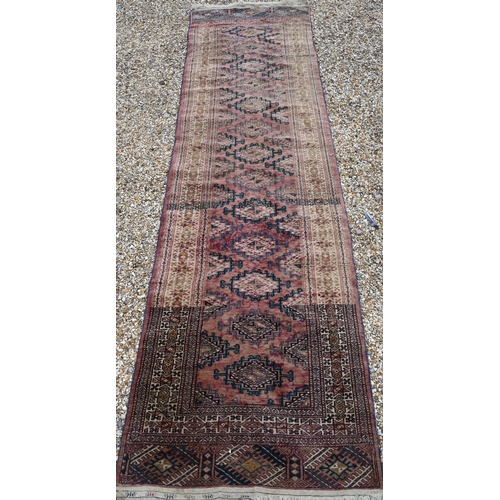 911 - An old Afghan washed red ground runner, 281 cm x 76 cm