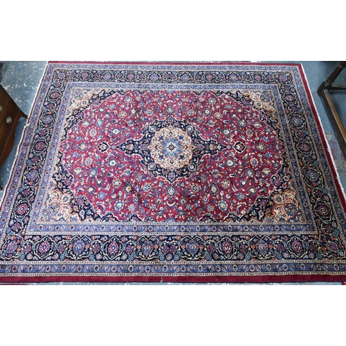 914 - A Persian Meshed carpet, the red/blue ground centred by a floral medallion, 373 cm x 300 cm